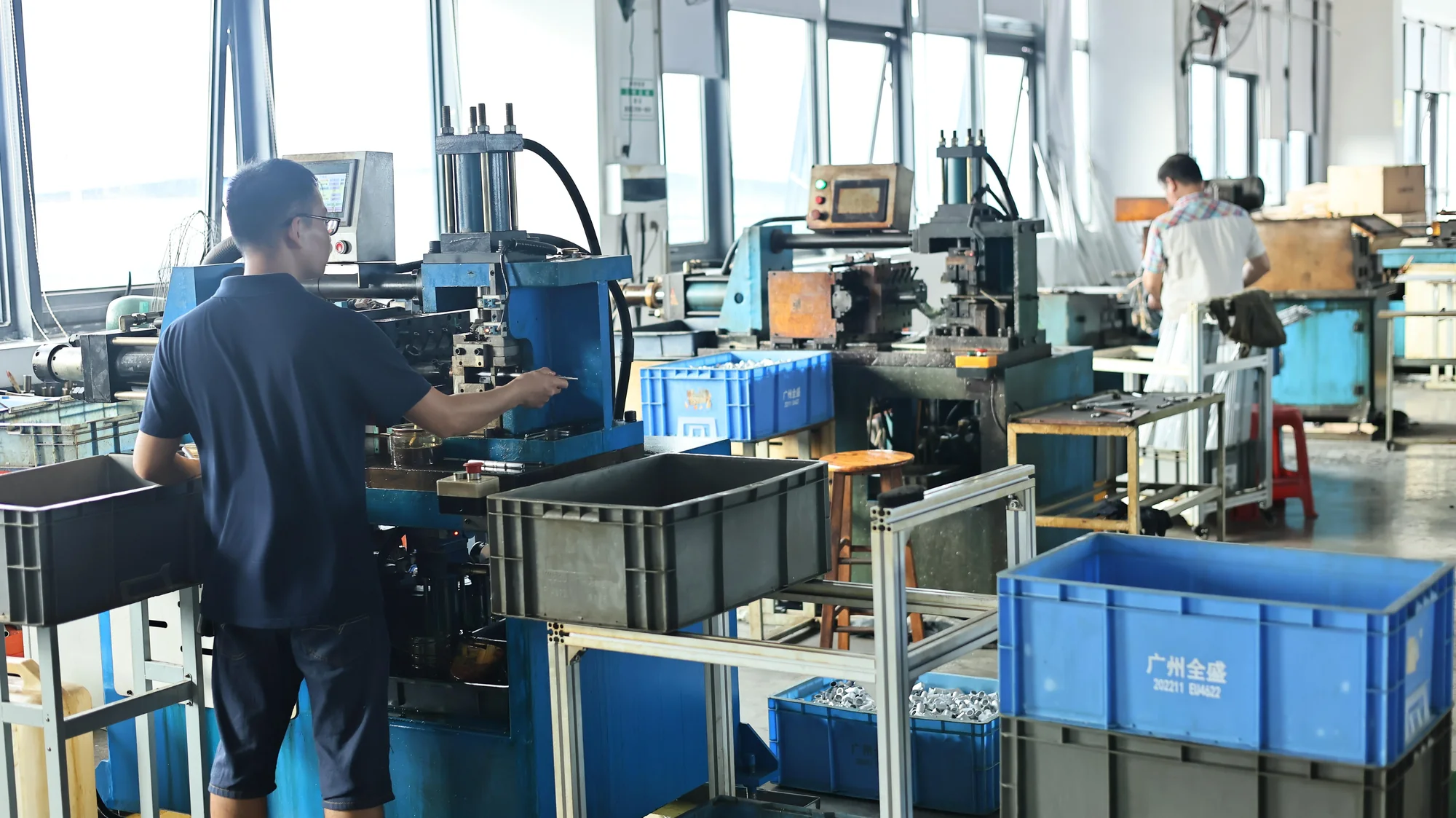 Workers operating component production equipment in a Chinese factory